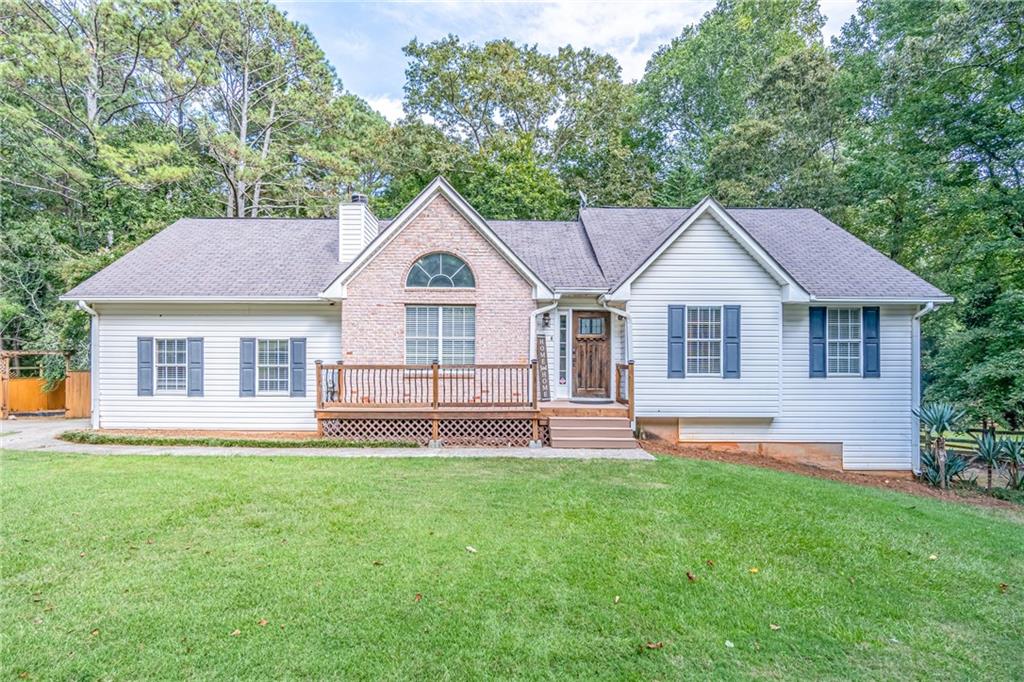 a front view of a house with a yard and green space