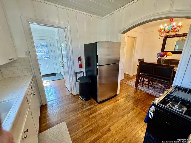 a kitchen with a refrigerator and wooden floor