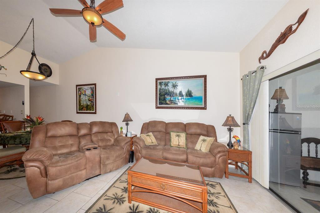 335 Coldeway Drive, Unit F21 Punta Gorda, FL 33950 - Photo 11 of 45 a living room with furniture a refrigerator and a chandelier
