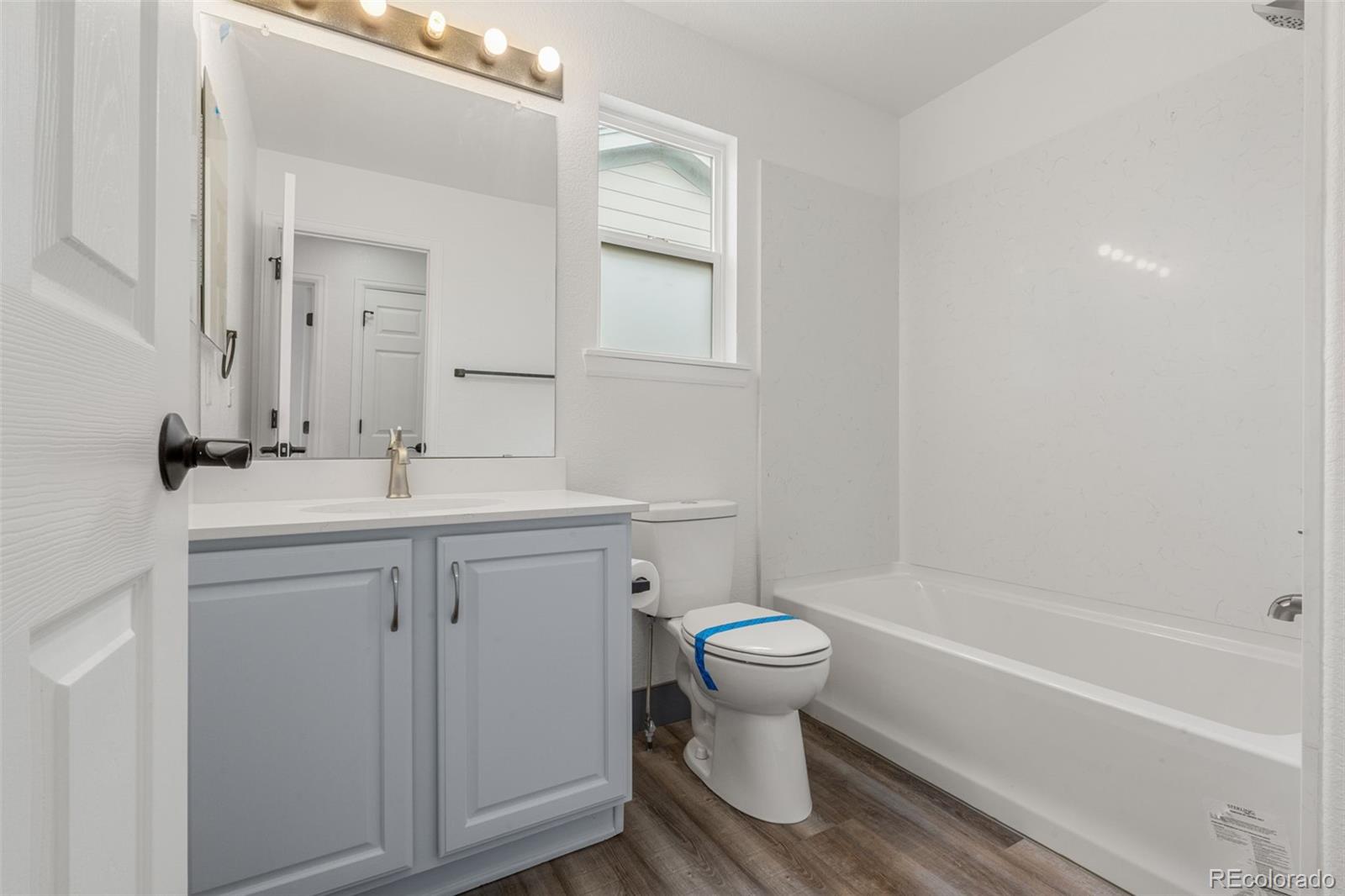 20412 East Chenango Place Aurora, CO 80015 - Photo 16 of 25 a bathroom with a sink toilet a bathtub and a vanity