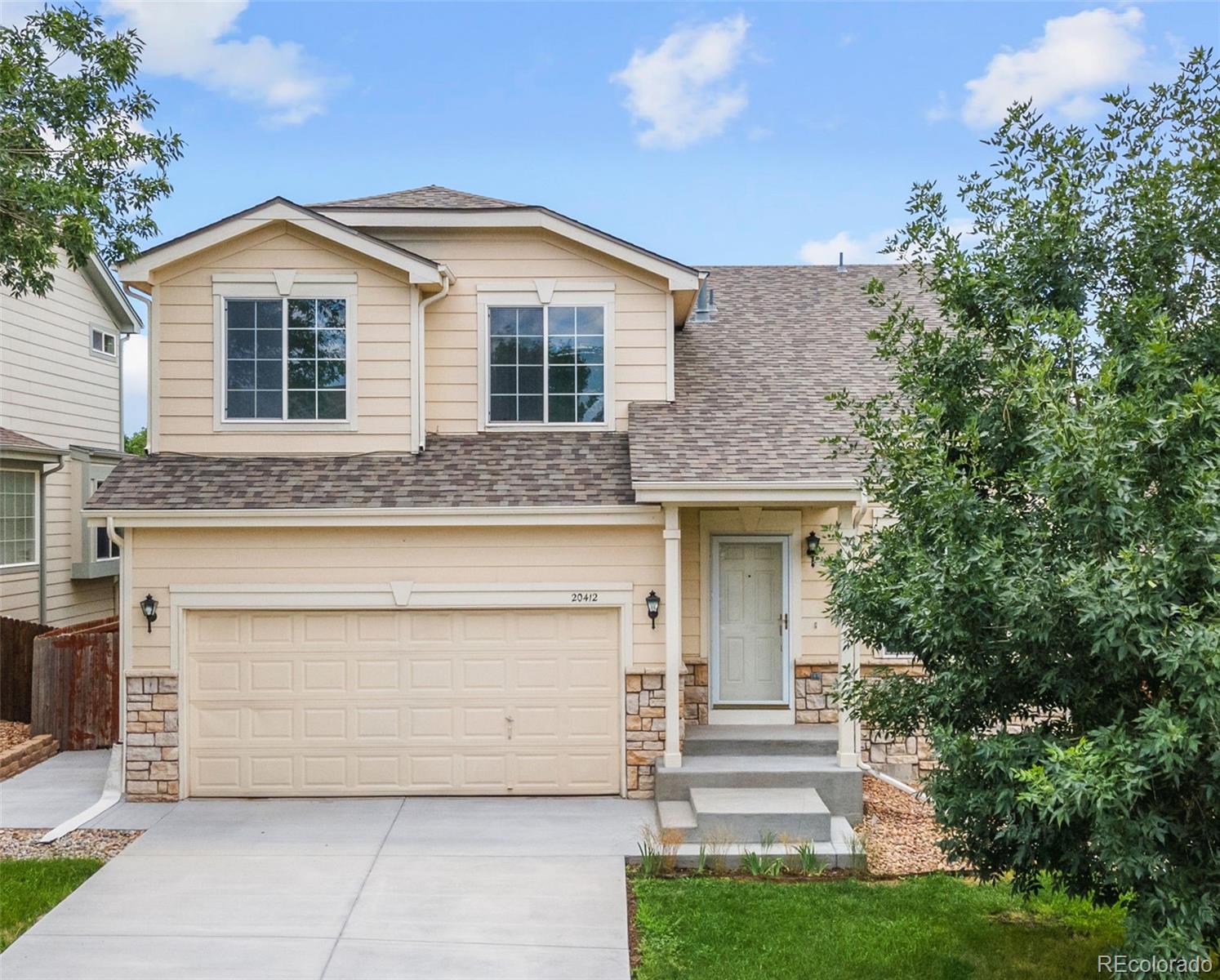 20412 East Chenango Place Aurora, CO 80015 - Photo 2 of 25 a front view of a house with a garden