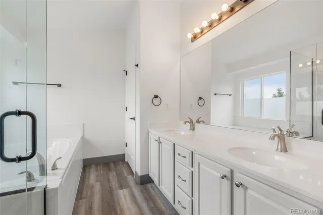 a spacious bathroom with a double vanity sink a mirror and a shower