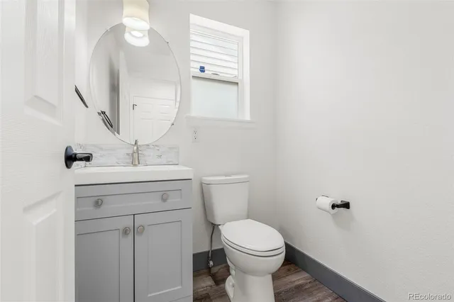 a bathroom with a sink a toilet and mirror