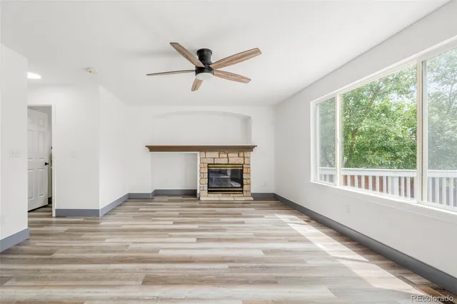 a view of an empty room with a window and a kitchen