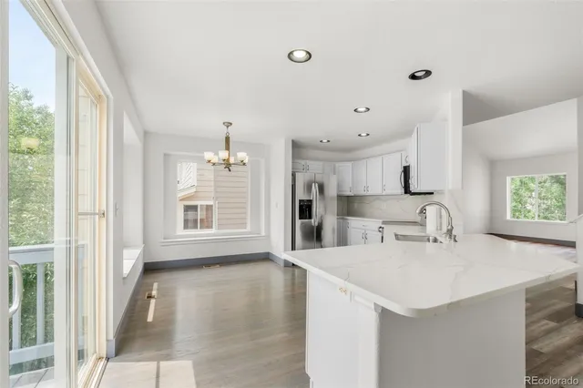 a kitchen with granite countertop a sink cabinets and wooden floor