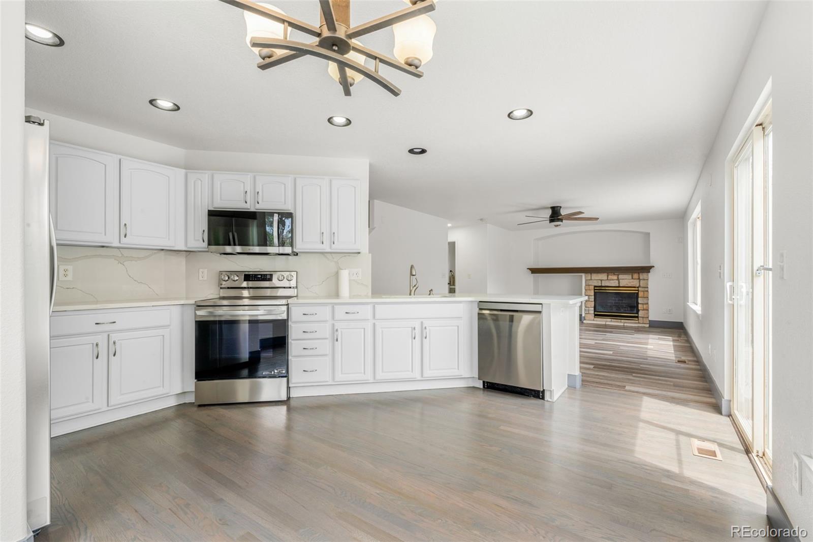 20412 East Chenango Place Aurora, CO 80015 - Photo 9 of 25 a kitchen with granite countertop white cabinets and stainless steel appliances