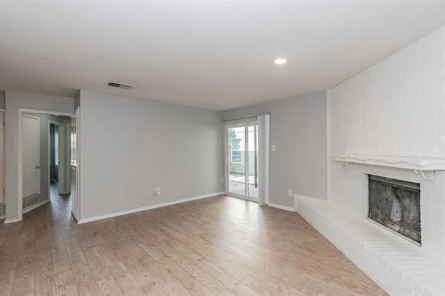 a view of an empty room with window and fire place