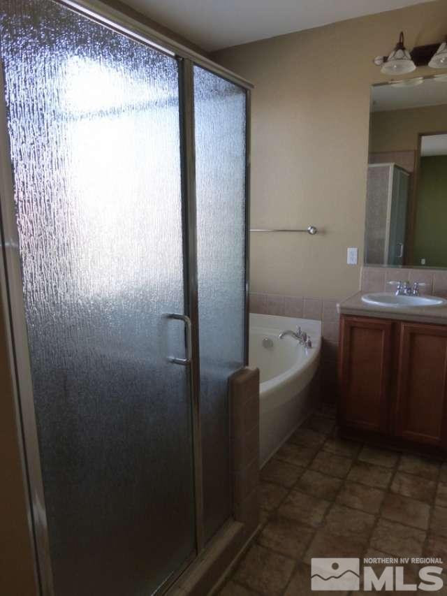 2471 Spring Flower Drive Reno, NV 89521 - Photo 11 of 20 a bathroom with a bathtub sink vanity and toilet