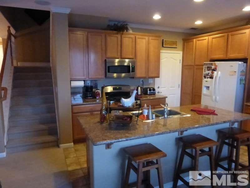 2471 Spring Flower Drive Reno, NV 89521 - Photo 4 of 20 a kitchen with a dining table chairs and refrigerator