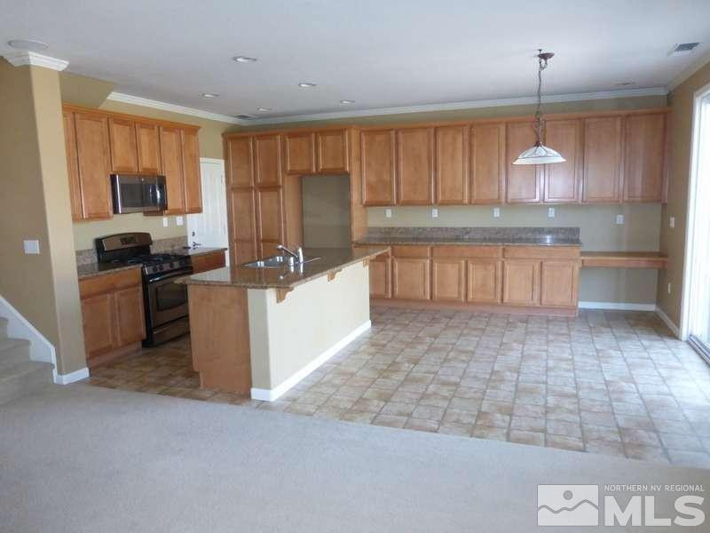 2471 Spring Flower Drive Reno, NV 89521 - Photo 6 of 20 a kitchen with a refrigerator a stove top oven a sink dishwasher and wooden cabinets