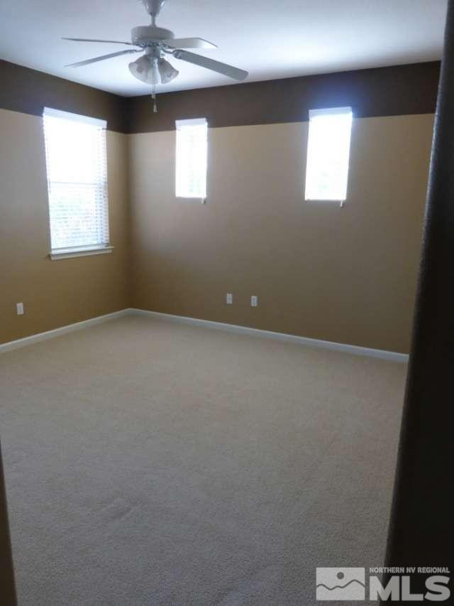 2471 Spring Flower Drive Reno, NV 89521 - Photo 9 of 20 en empty room with windows and chandelier fan