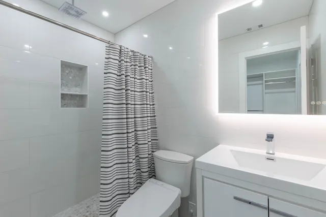 a bathroom with a sink a toilet and shower