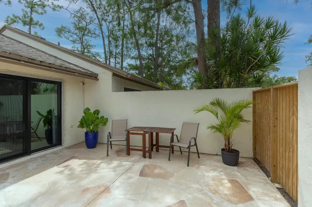 a view of a patio with table and chairs potted plants with wooden fence