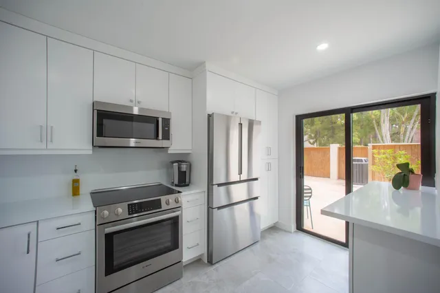 a kitchen with stainless steel appliances a stove sink and microwave