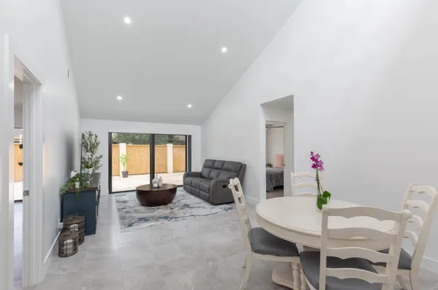 a dining room with furniture and potted plants