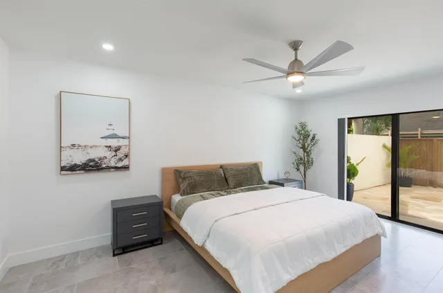 a bedroom with a large bed and a ceiling fan