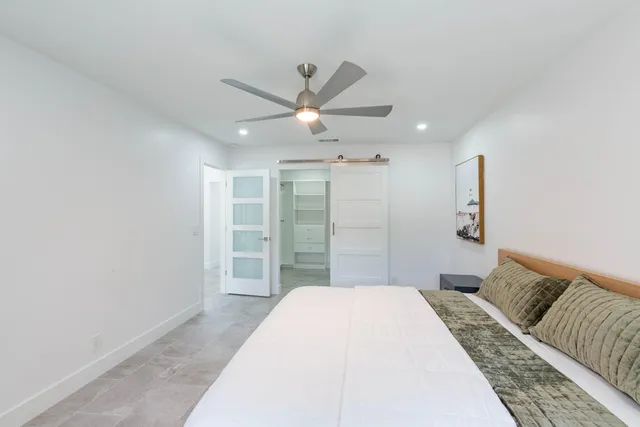 a bedroom with a large bed and a chandelier