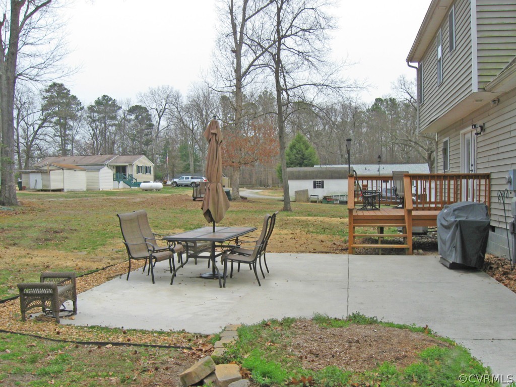 12619 Harrowgate Road Chester, VA 23831 - Photo 7 of 8 a view of a patio with dining table and chairs with wooden floor