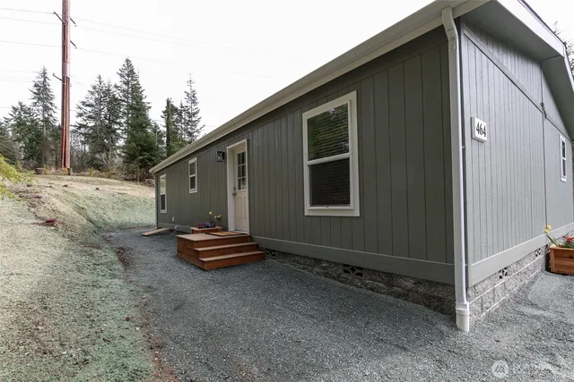 a aerial view of a house with yard and trees in the background