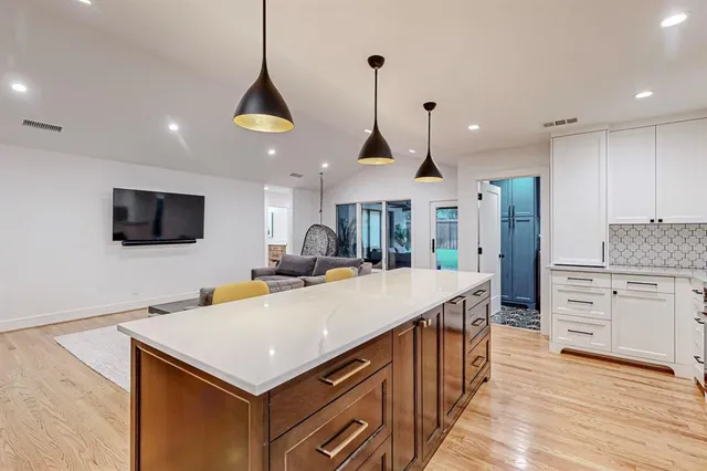 a kitchen with stainless steel appliances kitchen island granite countertop a stove a sink and a refrigerator