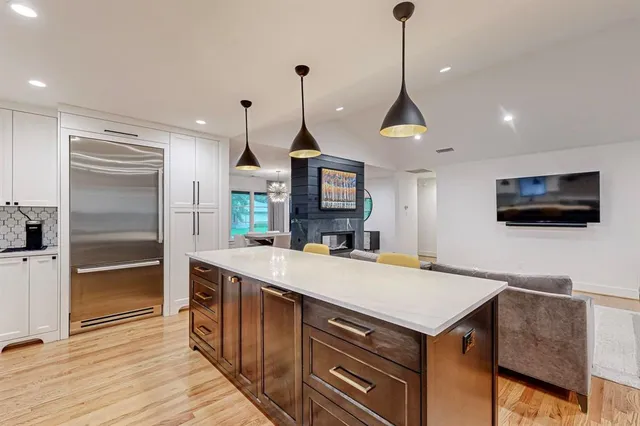 a kitchen with stainless steel appliances granite countertop a sink a microwave a refrigerator and a stove