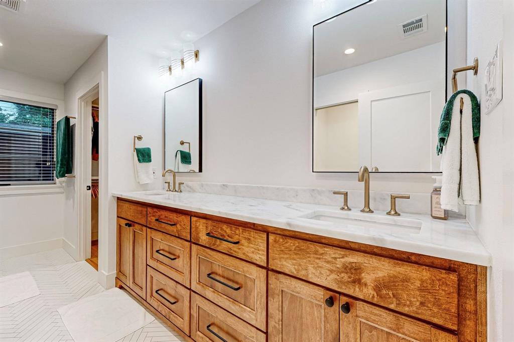 4423 Springside Lane Dallas, TX 75214 - Photo 22 of 40 a bathroom with double sink and a mirror