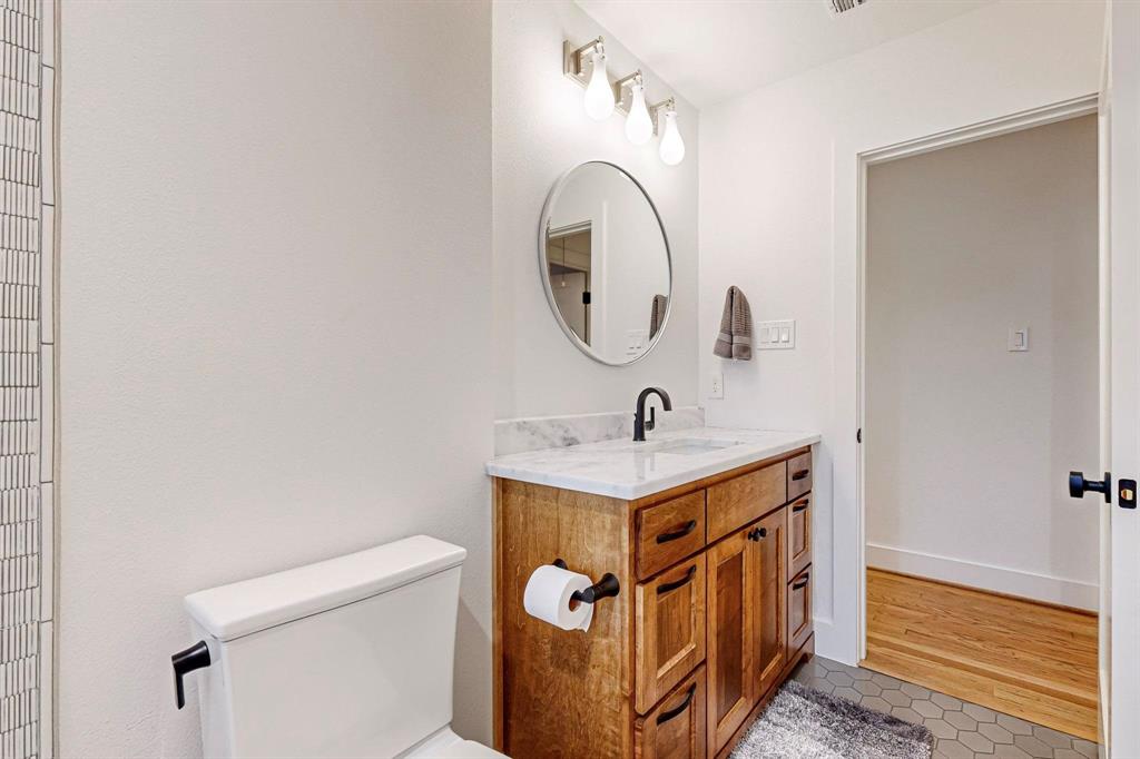4423 Springside Lane Dallas, TX 75214 - Photo 30 of 40 a bathroom with a sink a toilet and a mirror