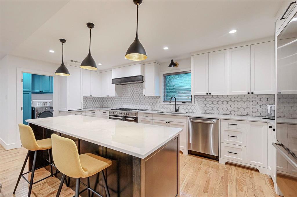 4423 Springside Lane Dallas, TX 75214 - Photo 3 of 40 a kitchen with stainless steel appliances granite countertop a stove a sink and white cabinets with wooden floor
