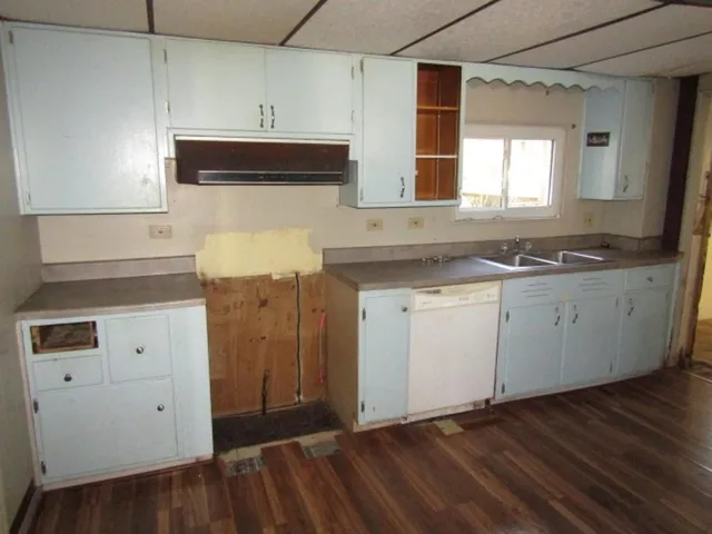 a kitchen with a sink cabinets and wooden floor