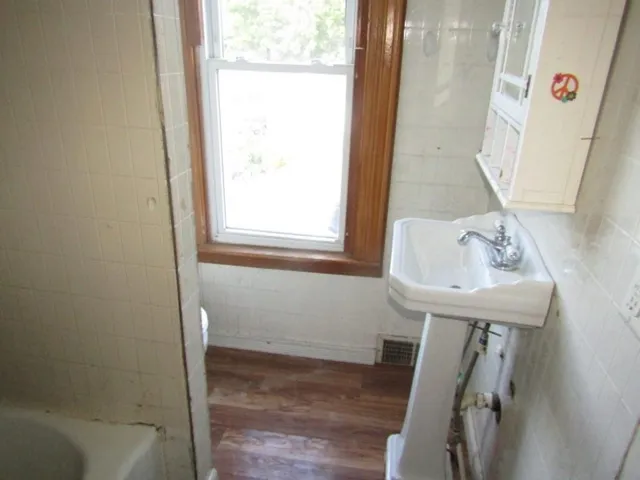 a bathroom with a sink a window and tub