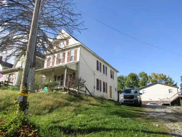 a view of a house with backyard and sitting area