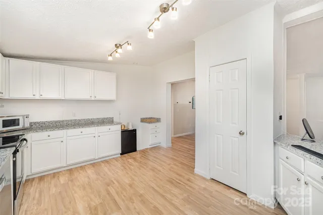a kitchen with a sink cabinets and wooden floor