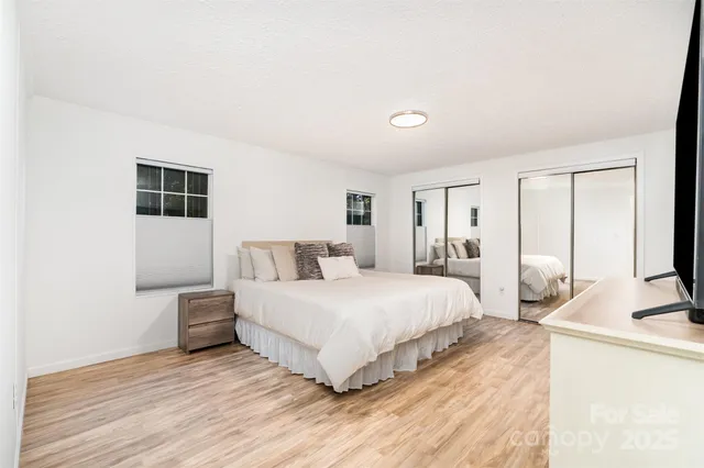 a bedroom with a bed and a large mirror