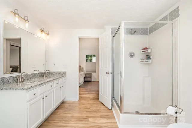 a en suite bathroom with a granite countertop sink mirror and shower