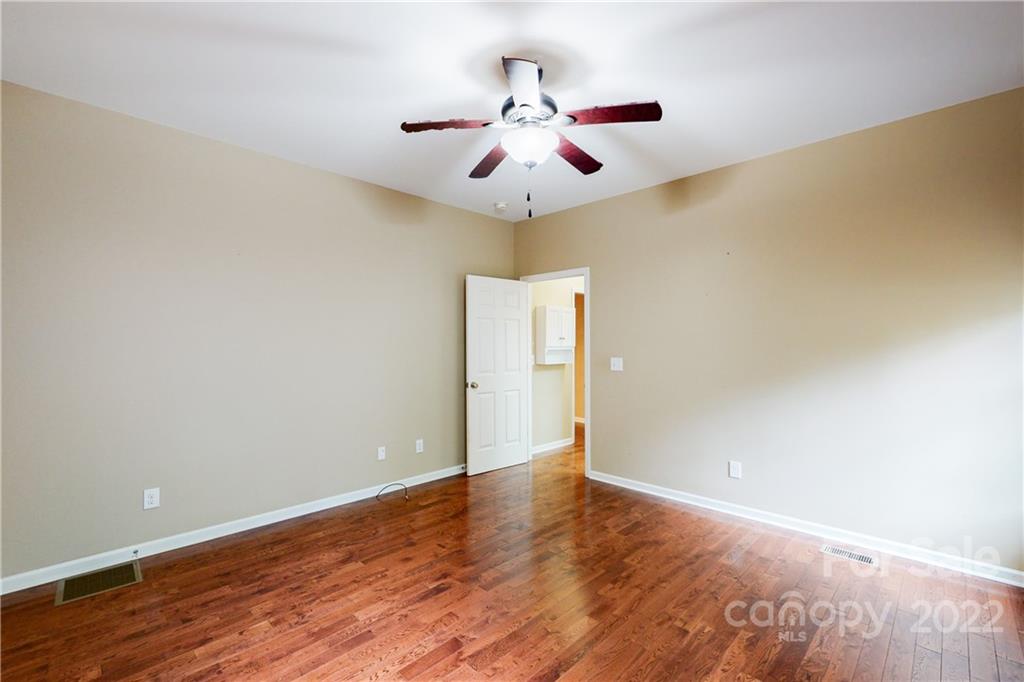 140 Beaver Dam Road Badin Lake, NC 28127 - Photo 21 of 40 an empty room with wooden floor chandelier fan and closet area