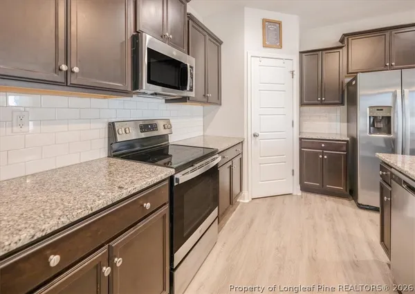 a kitchen with stainless steel appliances granite countertop a sink stove and microwave