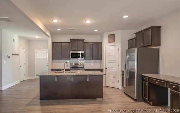 a view of a kitchen with wooden floor and electronic appliances