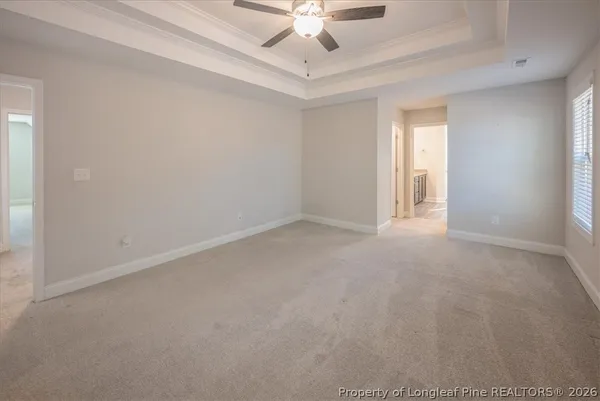 an empty room with a window and a ceiling fan