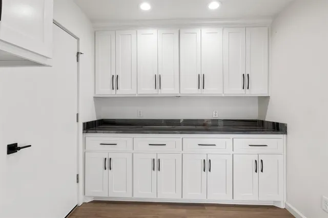 a kitchen with white cabinets and sink