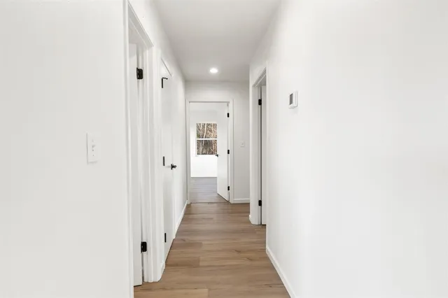 a view of a hallway with wooden floor