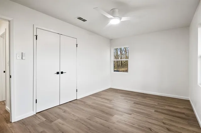 a view of an empty room with wooden floor