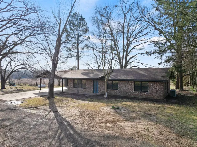 a front view of a house with a yard and covered with snow
