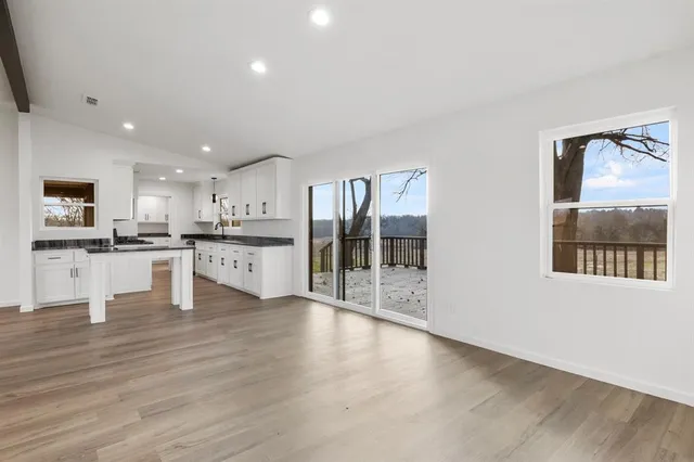 a large kitchen with stainless steel appliances granite countertop a lot of counter space and wooden floor