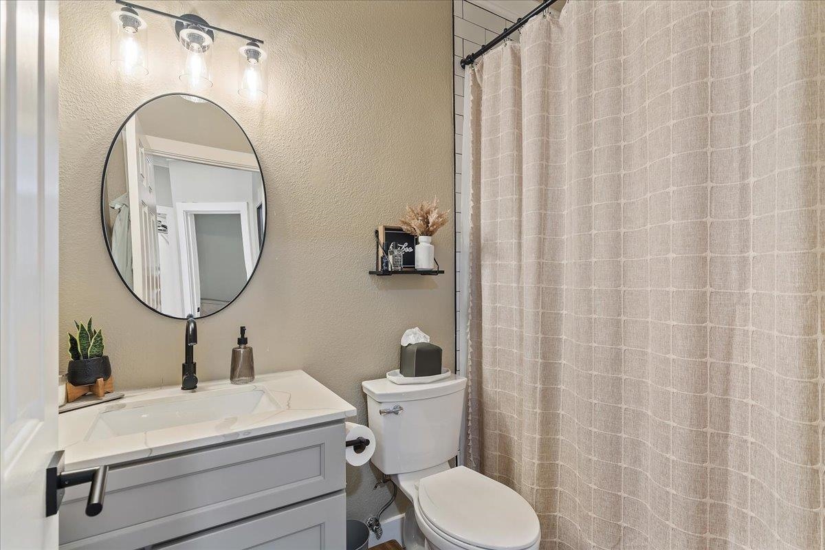 1105 Deerpark Road Oakley, CA 94561 - Photo 20 of 25 Bathroom with a textured wall, vanity, and a shower with curtain