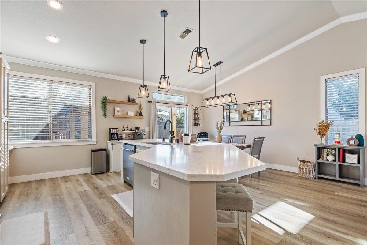 1105 Deerpark Road Oakley, CA 94561 - Photo 8 of 25 Kitchen with pendant lighting, a breakfast bar area, light wood-style flooring, ornamental molding, and vaulted ceiling