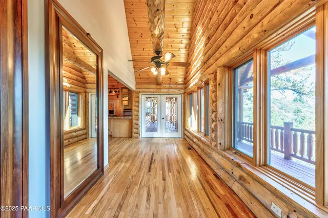 a view of empty room with wooden floor and fan