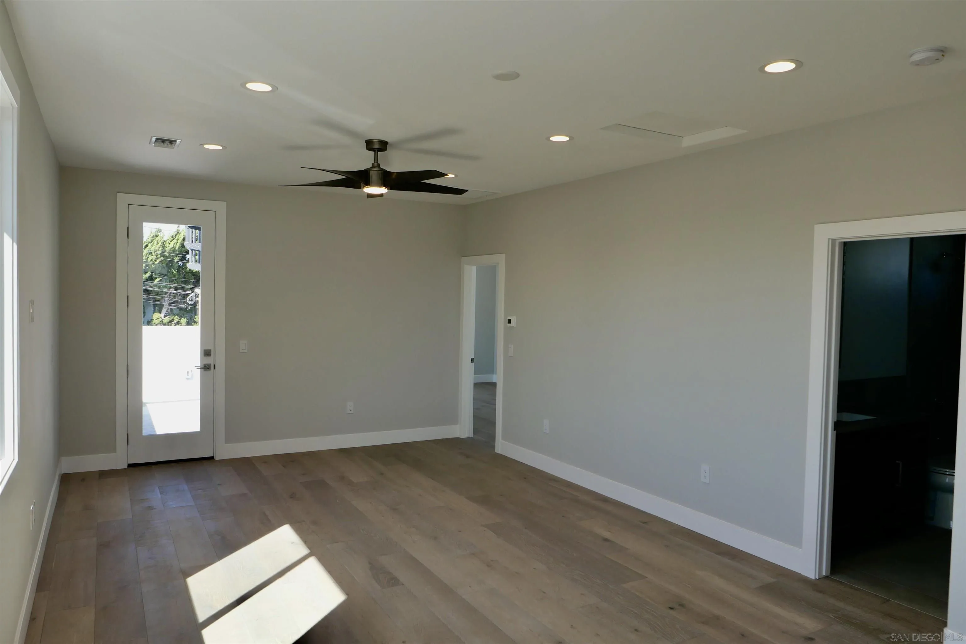 1776 Cable Street San Diego, CA 92107 - Photo 12 of 26 an empty room with wooden floor ceiling fan and windows