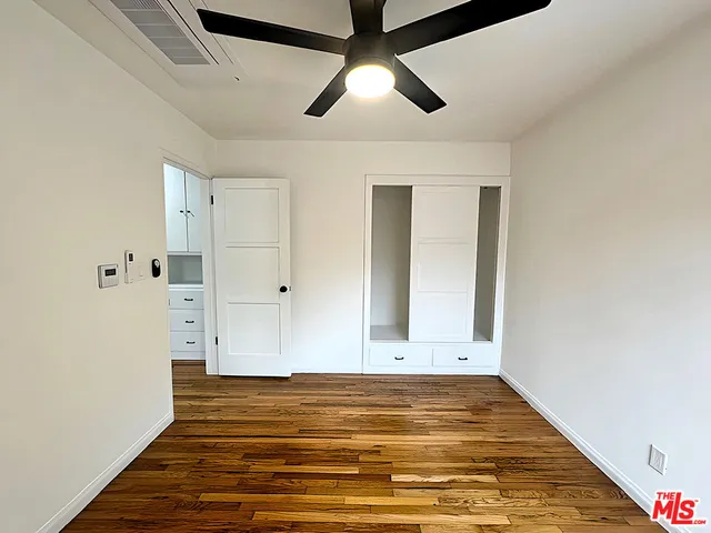 a view of empty room with wooden floor