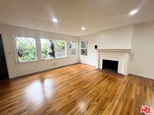 a view of empty room with wooden floor and fireplace