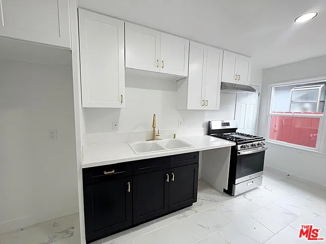 a kitchen with stainless steel appliances granite countertop a sink stove and cabinets